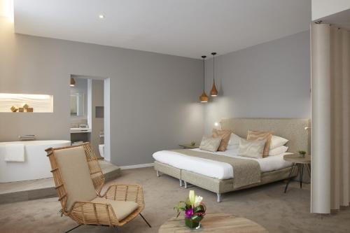 - une chambre avec un lit et une chaise dans l'établissement Logis Hôtel - Hôtel Restaurant Maison Claude Darroze, à Langon