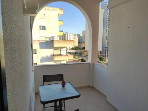 einen Tisch auf einem Balkon mit Blick auf ein Gebäude in der Unterkunft calm beach apartement in Portimão