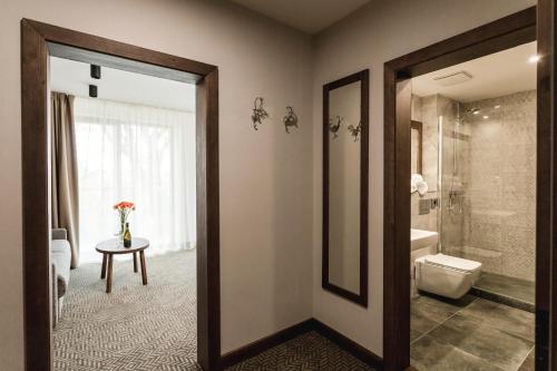 łazienka z prysznicem, toaletą i stołem w obiekcie ARIETES MARMONT Resort w mieście Tatranska Strba