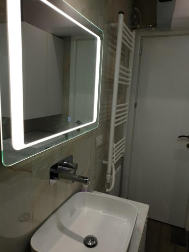 a bathroom with a white sink and a mirror at Vacation Apartment near the lake Apartament afer liqenit in Pogradec