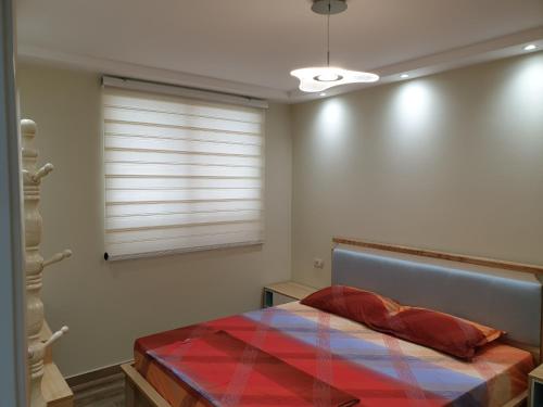 a bedroom with a bed and a window with blinds at Vacation Apartment near the lake Apartament afer liqenit in Pogradec