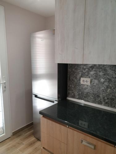 a kitchen with a refrigerator and a counter top at Vacation Apartment near the lake Apartament afer liqenit in Pogradec