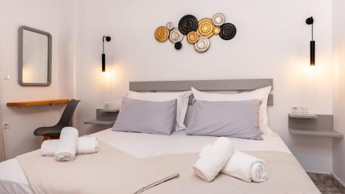 a bedroom with a large white bed with towels on it at Marina's Studios in Perivolos