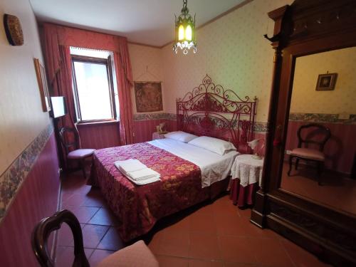 Schlafzimmer mit einem Bett und einem Kronleuchter in der Unterkunft La suite del Cardinale in Montefiascone