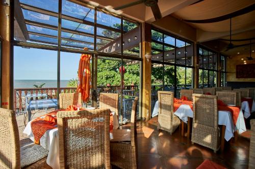 a restaurant with tables and chairs with a view of the ocean at Catembe Gallery Hotel in Maputo