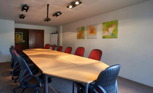 a conference room with a wooden table and chairs at Catembe Gallery Hotel in Maputo