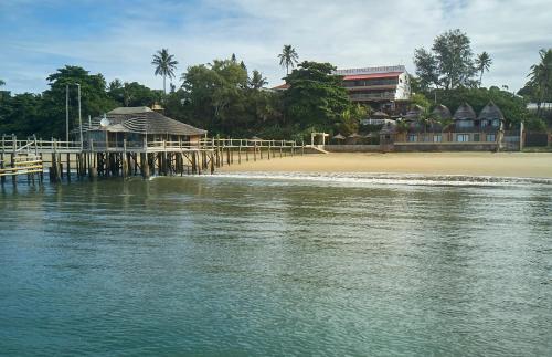 a view of a beach with a pier and a building at Catembe Gallery Hotel in Maputo