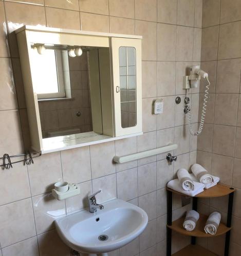 a bathroom with a sink and a mirror and towels at Apartments Punta in Seline