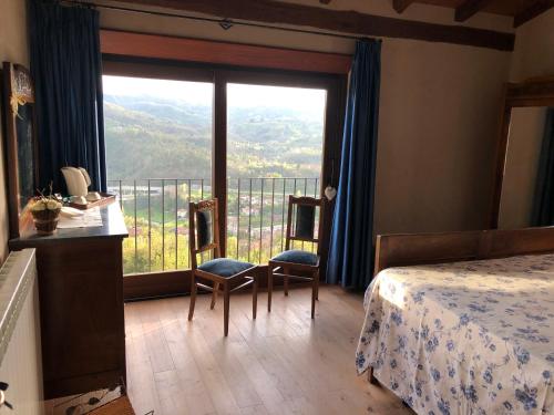 - une chambre avec un lit et une grande fenêtre avec vue dans l'établissement RESIDENZA CIMA LE VIGNE, à Millesimo
