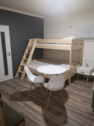 a bunk bed with a table and two chairs in a room at Penzion-Cukroška in Hlušovice