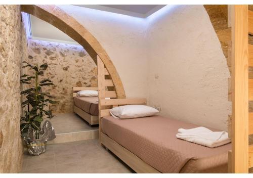 a room with two beds and an arched doorway at Poseidon Apartments in Kissamos