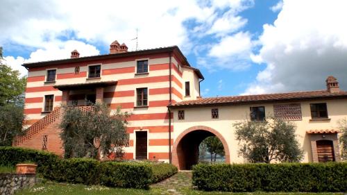 un edificio naranja y blanco con un arco en Poggio di Villa Fano, en Citerna