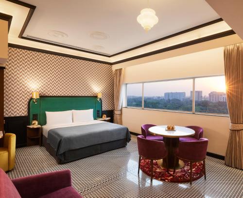 pokój hotelowy z łóżkiem, stołem i krzesłami w obiekcie The Connaught, New Delhi- IHCL SeleQtions w Nowym Delhi