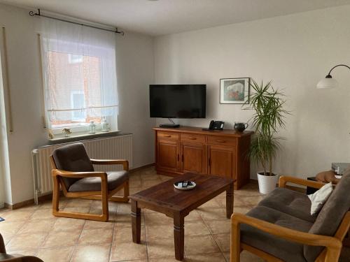 a living room with a couch and a tv at Hellinghaus FeWo 2 Klippenfänger in Wyk auf Föhr