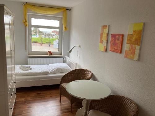 Habitación pequeña con cama, mesa y sillas en Hellinghaus FeWo 2 Klippenfänger, en Wyk auf Föhr