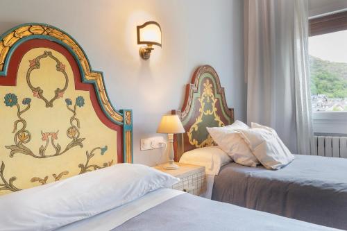 a hotel room with two beds and a window at HostalTina in Bossost