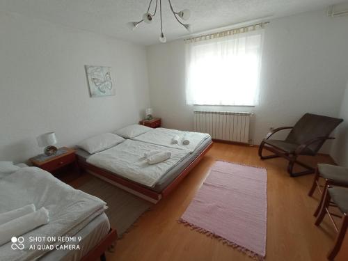 a bedroom with a bed and a chair and a window at Apartment LIKA in Gospić