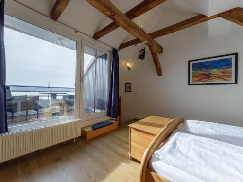 ein Schlafzimmer mit einem Bett und einem großen Fenster in der Unterkunft Ferienwohnung Kietzspeicher in Waren (Müritz)