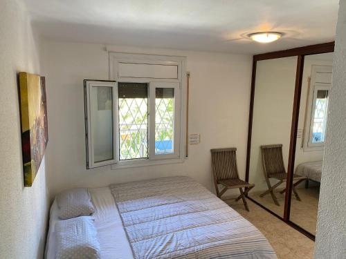 1 dormitorio con 1 cama, ventana y 2 sillas en Chamonix, en Salou