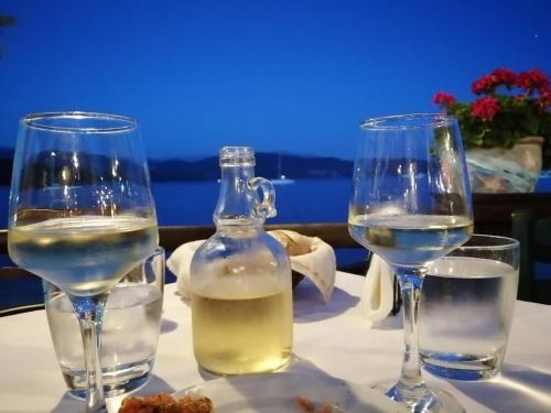 two wine glasses and a bottle of water on a table at Mavra Studios in Lygia