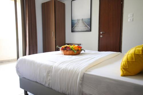a basket of fruit sitting on top of a bed at Miami Beach Hotel Tel Aviv in Tel Aviv
