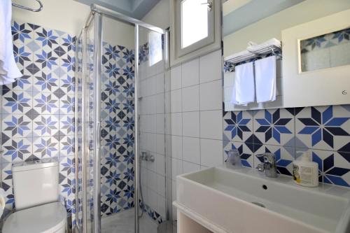 a bathroom with a shower and a toilet and a sink at Avra Pension in Ios Chora