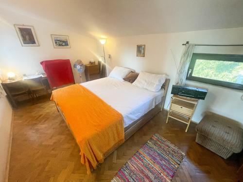 ein Schlafzimmer mit einem Bett mit einer orangefarbenen Decke in der Unterkunft Apartman Blažina in Jadranovo