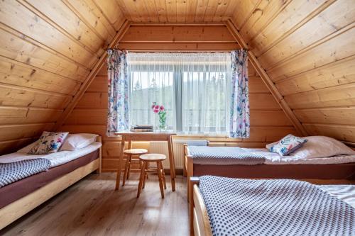 een kamer met twee bedden en een raam bij Pawlikówka 2 in Zakopane
