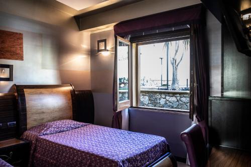 a small bedroom with a bed and a window at Hotel Garibaldi in Milazzo