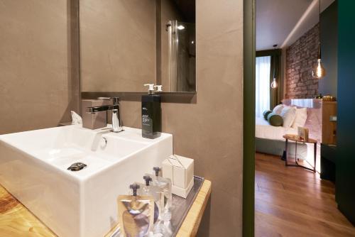 a bathroom with a white sink and a bedroom at 73 Boutique Hotel in Como