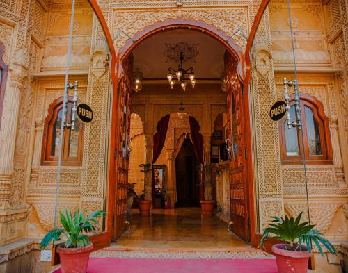 a hallway in a building with two potted plants at Hotel Lal Garh Fort And Palace in Jaisalmer