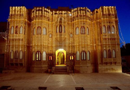 a building covered in christmas lights at night at Hotel Lal Garh Fort And Palace in Jaisalmer