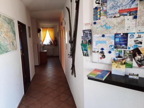 a hallway with a wall with magnets and papers at Penzion Lipno Jantar in Horní Planá