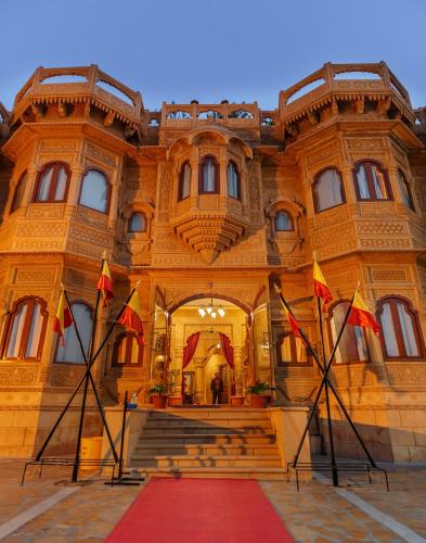 a large building with flags in front of it at Hotel Lal Garh Fort And Palace in Jaisalmer