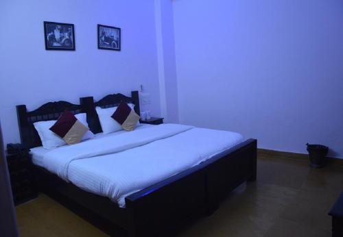 a bedroom with a large bed with white sheets and pillows at Hotel Lal Garh Fort And Palace in Jaisalmer