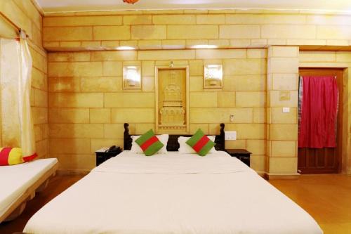 a bedroom with a large white bed in a room at Hotel Lal Garh Fort And Palace in Jaisalmer