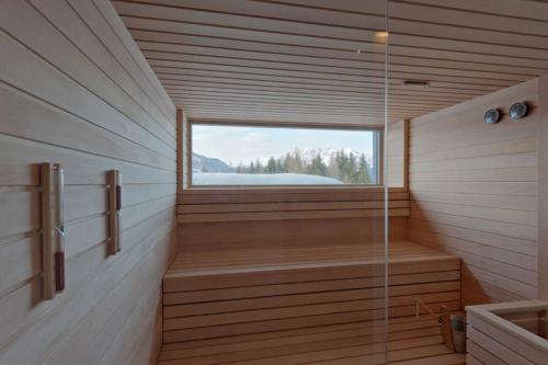 a room with a sauna with a window and a tub at Exclusive Alpenlodge ski in ski out Galsterberg in Pruggern