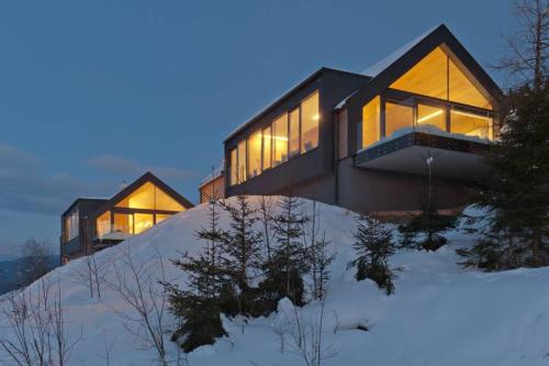 a house on top of a snow covered hill at Exclusive Alpenlodge ski in ski out Galsterberg in Pruggern