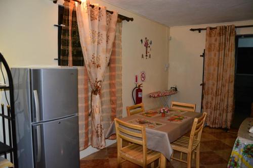 a kitchen with a dining table and a refrigerator at Villa dauphin in Bel Ombre