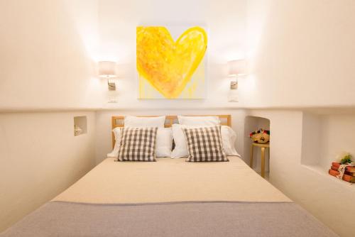 ein Schlafzimmer mit einem Bett mit einem Herzgemälde an der Wand in der Unterkunft Marina Suite by Wonderful Italy in Palermo