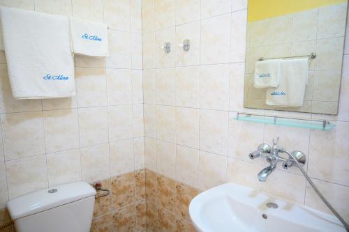 a bathroom with a white toilet and a sink at Effect Saint Mina in Sozopol