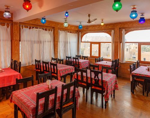 a restaurant with tables and chairs with red table cloth at Hotel Lal Garh Fort And Palace in Jaisalmer