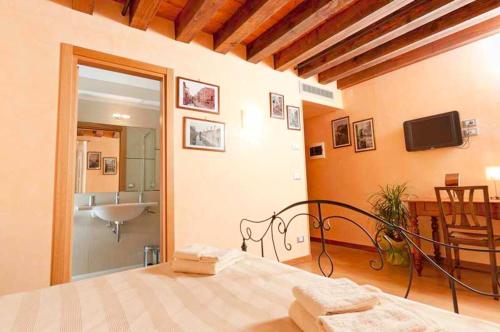 a bedroom with a bed and a bathroom with a sink at San Cassiano jacuzzi in Venice
