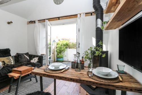 a living room with a table and a tv at Rocket Cart House in Landewednack