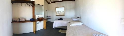 a room with two beds and a table in it at Pousada Porto Taipus in Marau