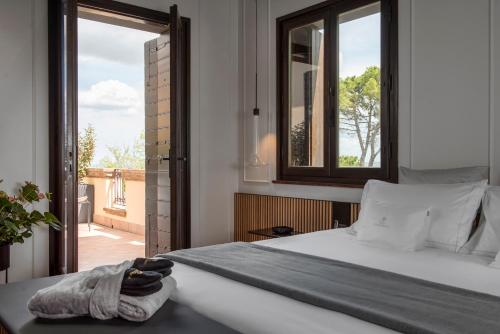 a bedroom with a bed and a large window at Relais Villa Margherita in Longiano