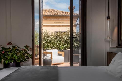a bedroom with a bed and a view of a patio at Relais Villa Margherita in Longiano