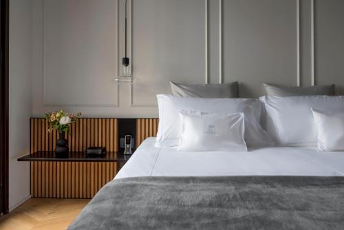 a large bed with white sheets and pillows on it at Relais Villa Margherita in Longiano