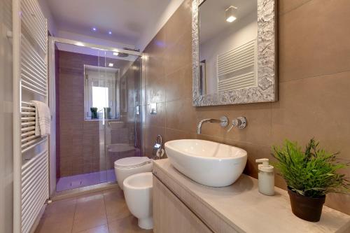 a bathroom with a sink and a toilet and a mirror at Margot Apartment by Mamo Florence in Florence