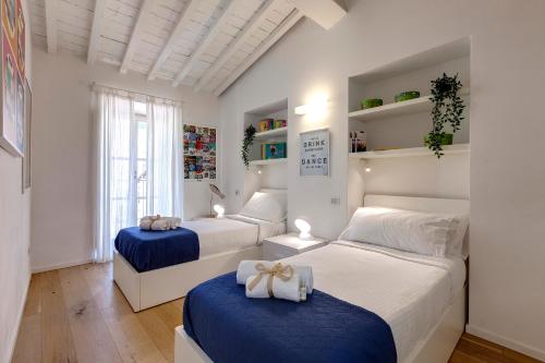 a bedroom with two beds with blue and white sheets at Margot Apartment by Mamo Florence in Florence
